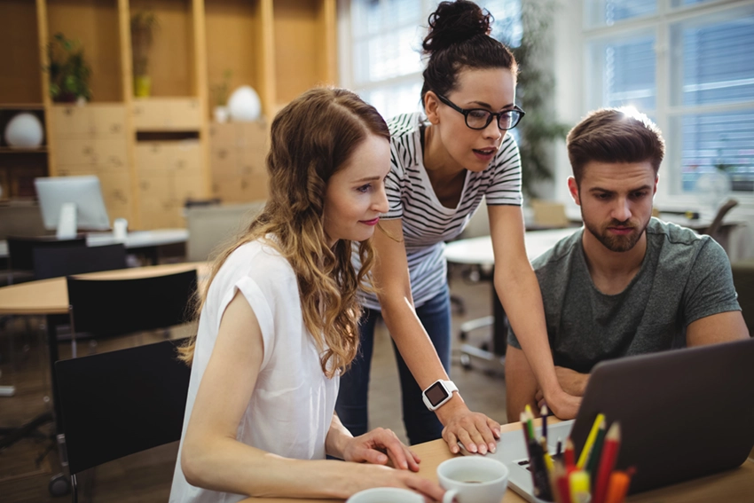 Grupo de personas trabajando frente a un ordenador